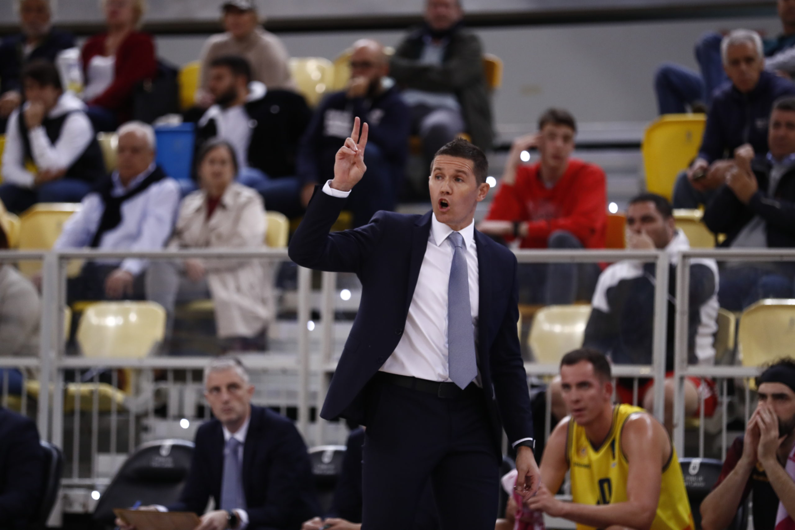 Entrenador Jaka Lakovic dirigiendo al equipo durante un partido, con público de fondo.