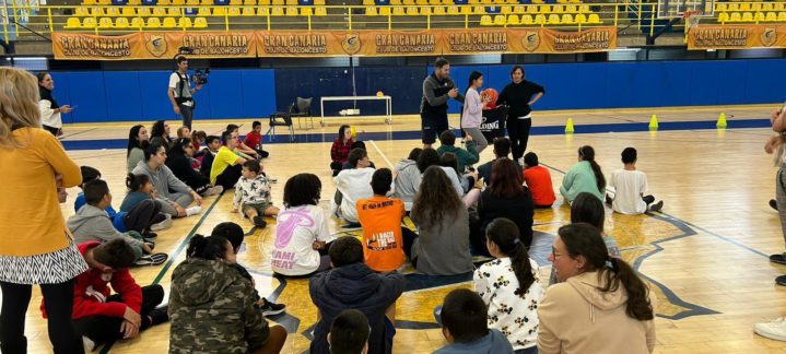 Actividad grupal en el campo de baloncesto con niños y entrenadores.
