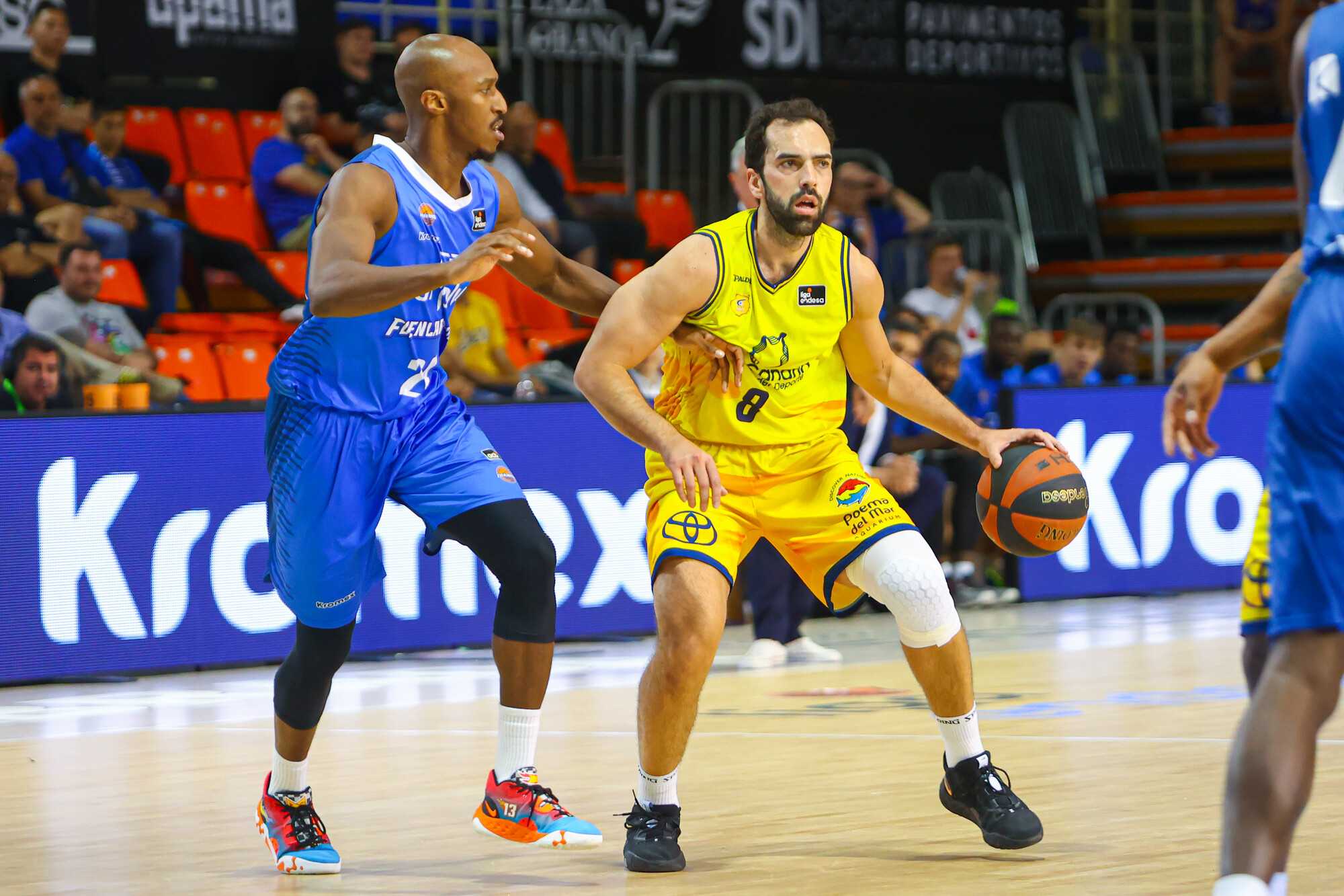 Jugador del Gran Canaria con balón, defendido por rival del Fuenlabrada en un partido.