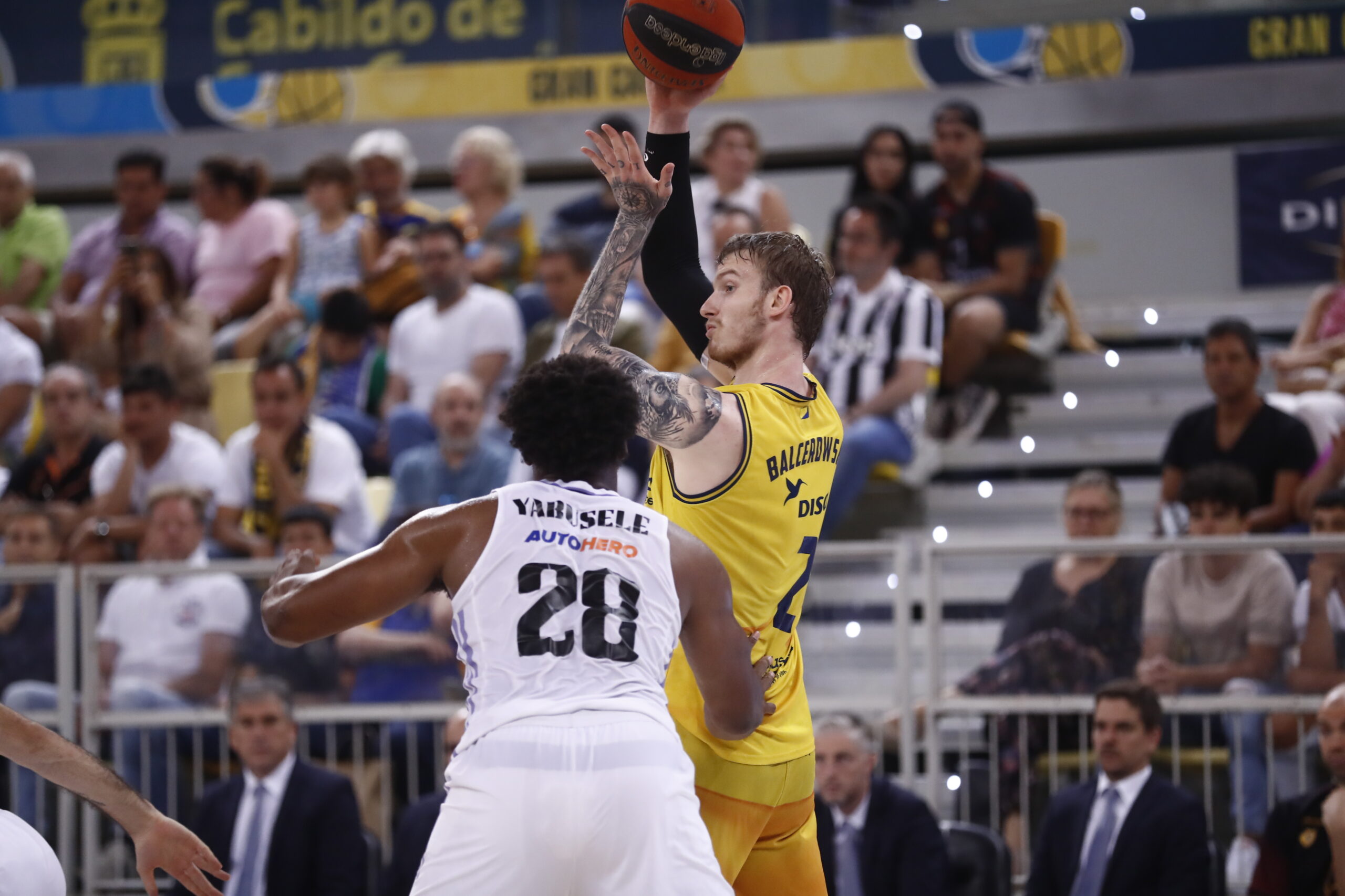 Balcerowski lanza a canasta mientras Yarusele defiende en un partido de baloncesto.