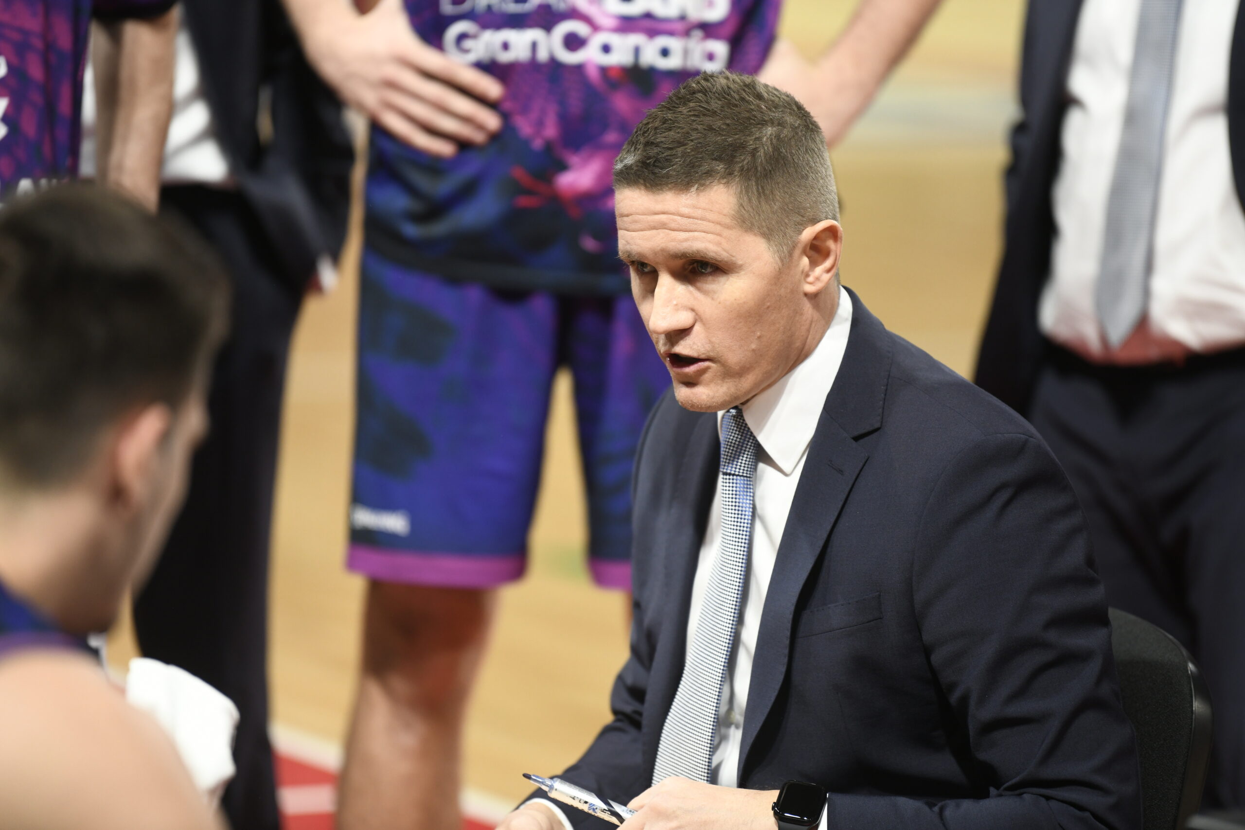 Entrenador Jaka Lakovic hablando con jugadores durante un tiempo muerto.