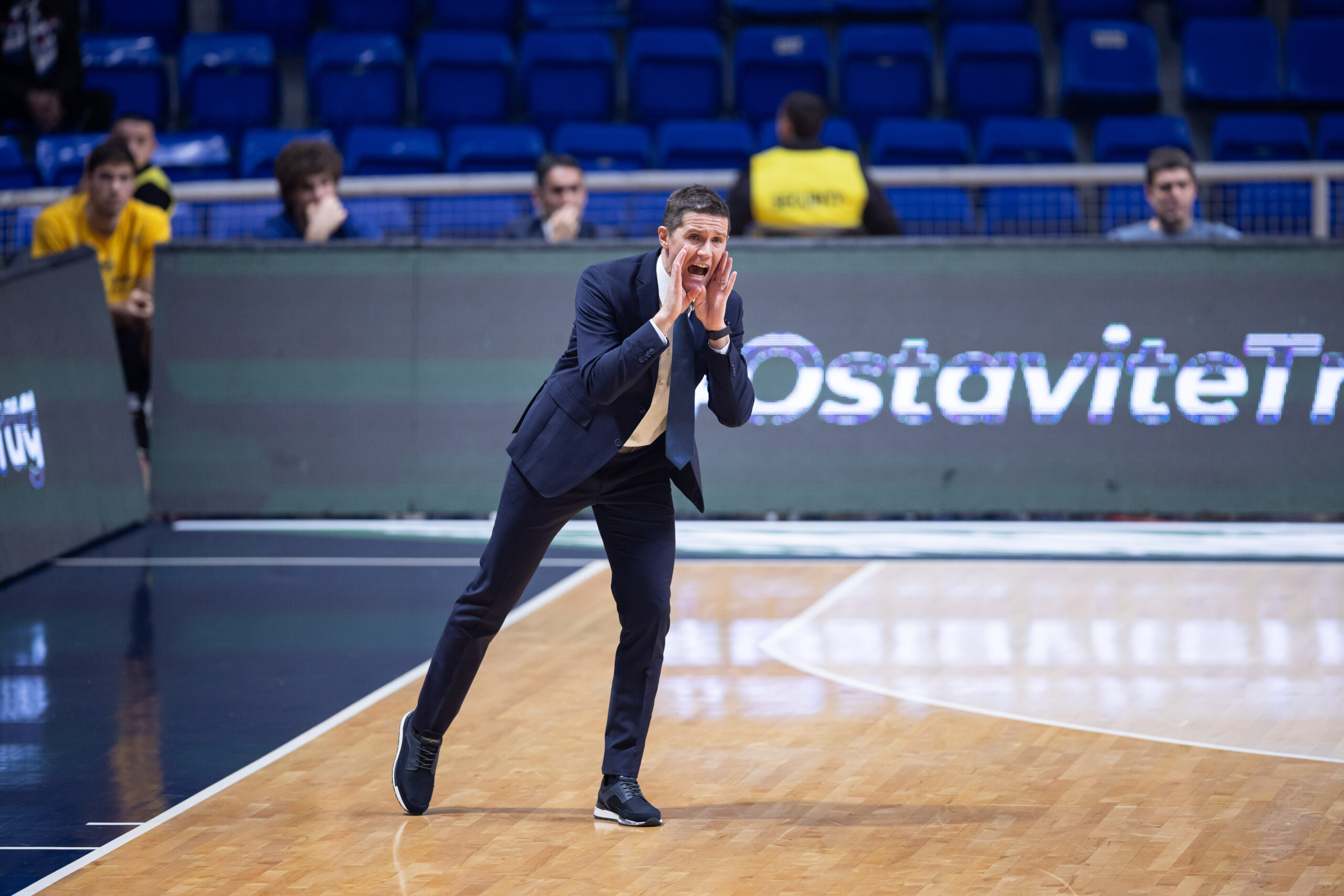 Entrenador animando a su equipo durante un partido de baloncesto en la cancha.