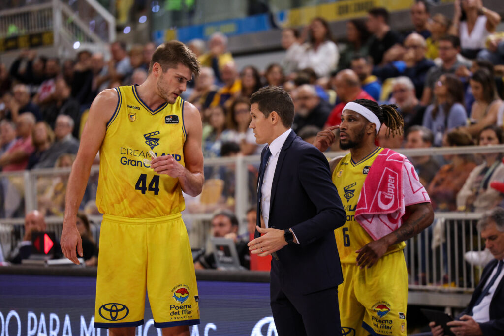 Jugadores del Club Baloncesto Gran Canaria conversan con el entrenador durante un partido.