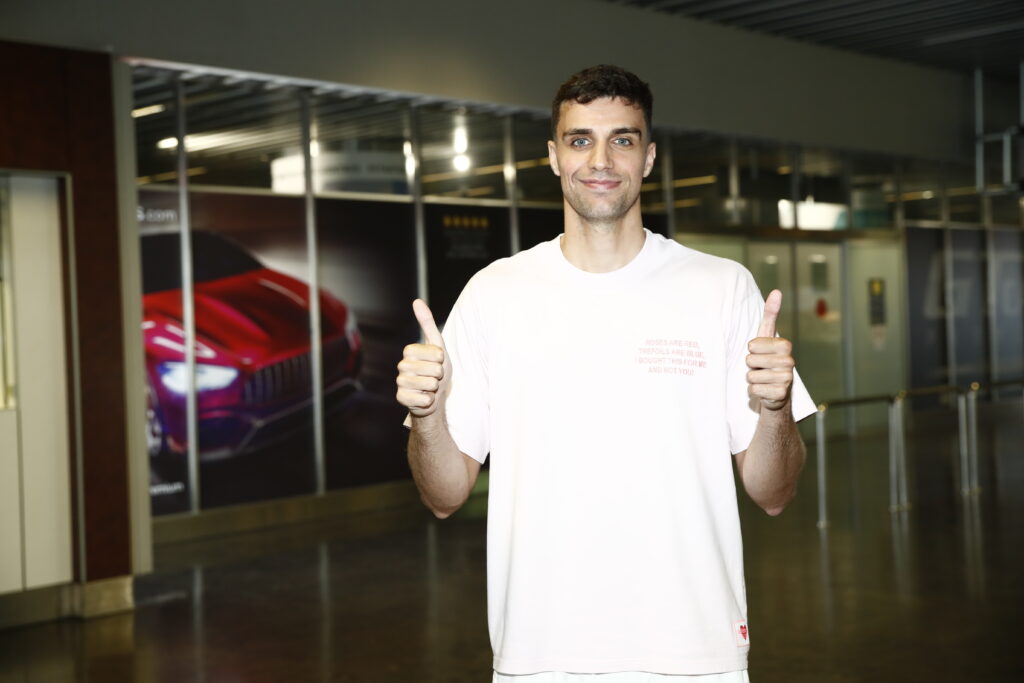 Carlos Alocén sonríe y muestra pulgares arriba en un entorno moderno.