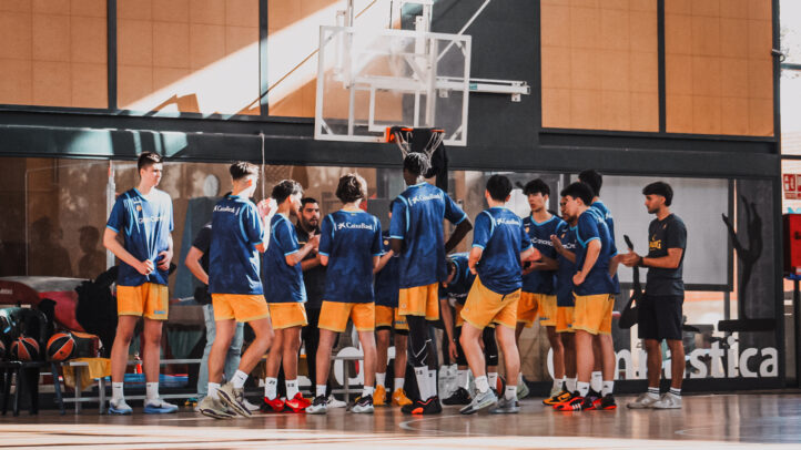 Jugadores del Gran Canaria cadete en un entrenamiento en pista, discutiendo estrategias.