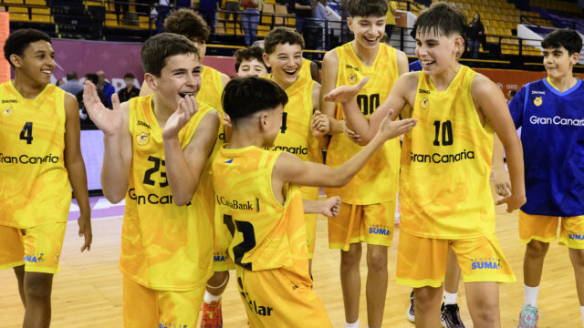 Niños celebrando con alegría tras un triunfo en la Minicopa Endesa, vistiendo camisetas amarillas.