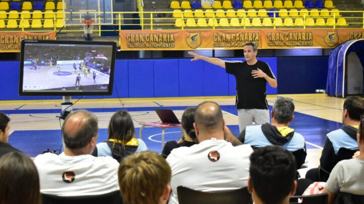 unidos en una fructífera formación de entrenadores",Taller de formación de entrenadores con Carlos Frade y una pantalla mostrando jugadas.