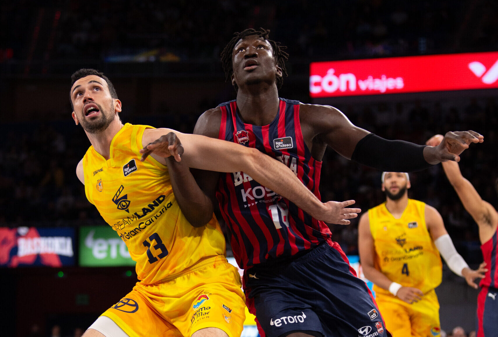 Dos jugadores de baloncesto compiten por el balón en un partido vibrante.