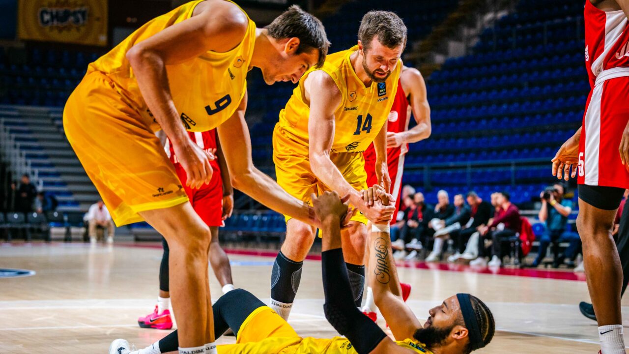 Tres jugadores del Club Baloncesto Gran Canaria ayudan a un compañero caído en la cancha.