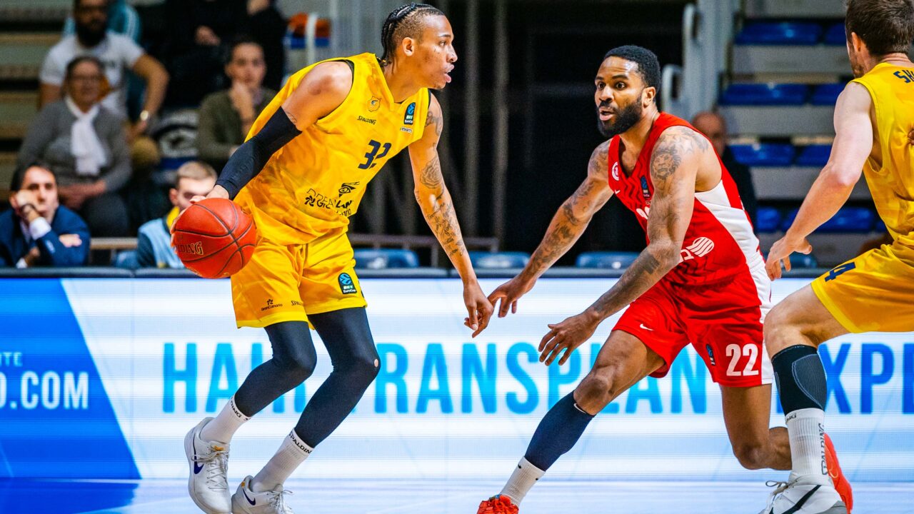 Jugador del CB Gran Canaria driblando el balón mientras es defendido por un adversario.