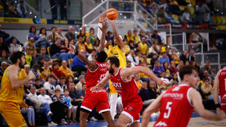 Caleb Homesley lanza a canasta durante un intenso partido de baloncesto.
