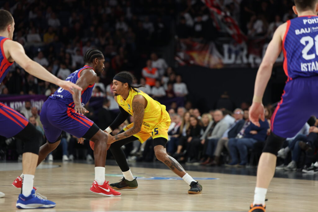 Jugadores de baloncesto en acción durante un partido, con impactos y defensa en juego.