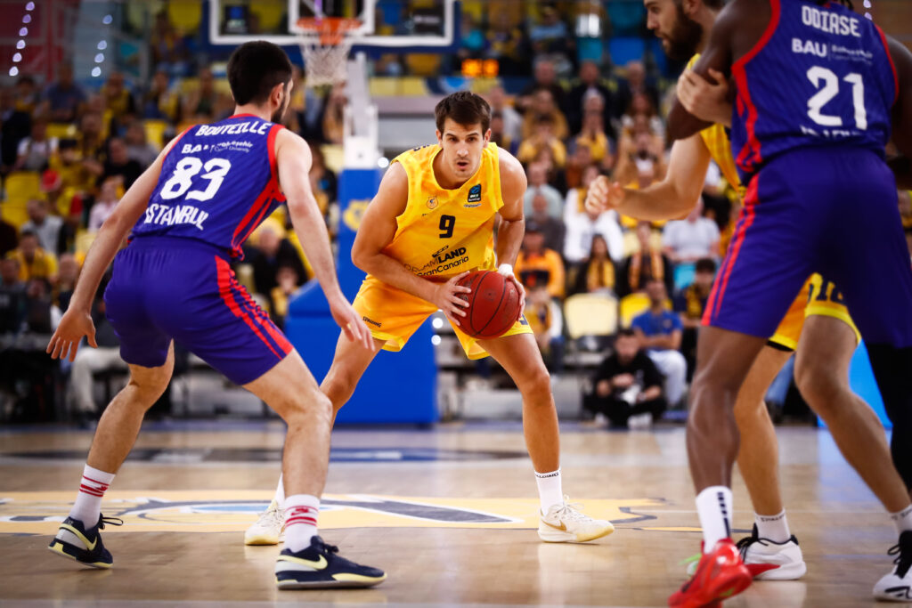 Jugadores del Gran Canaria y su rival en acción durante un partido de baloncesto.