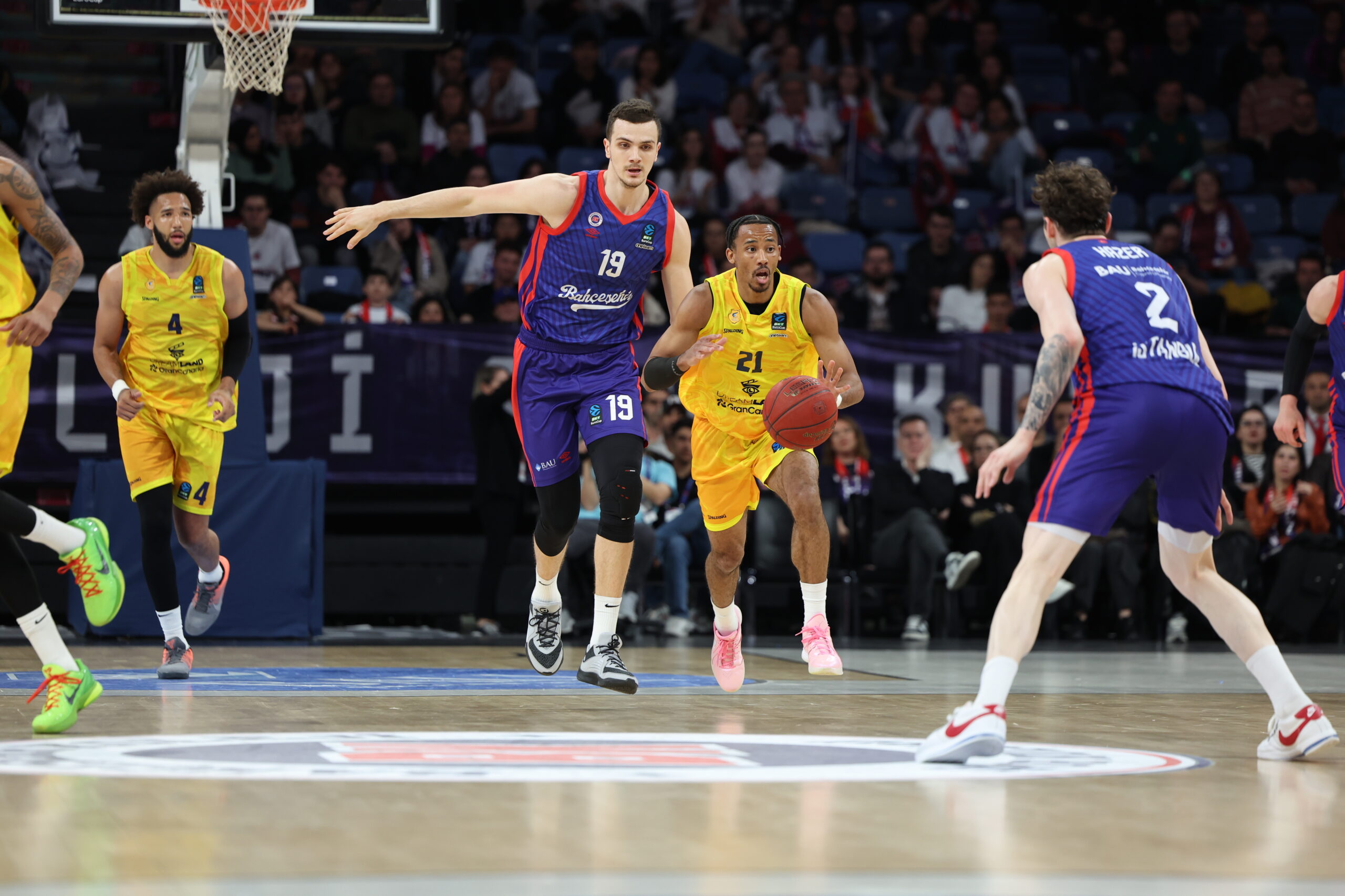 Jugadores de baloncesto en acción durante un partido en la cancha.