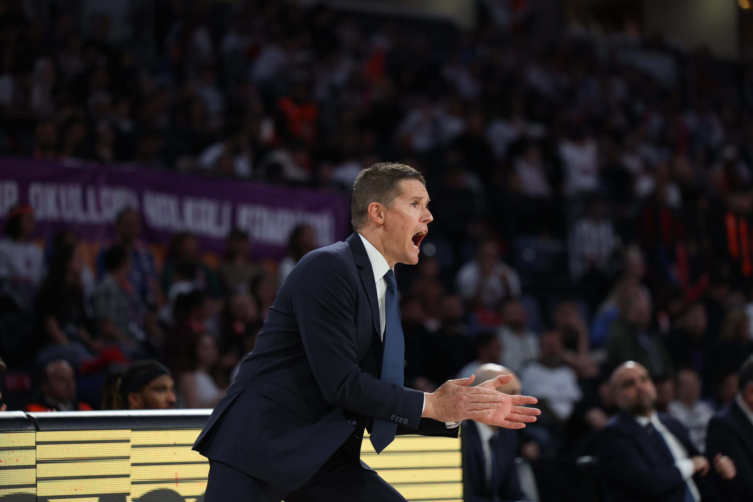 Entrenador en acción, dirigiendo al equipo durante un partido de baloncesto.