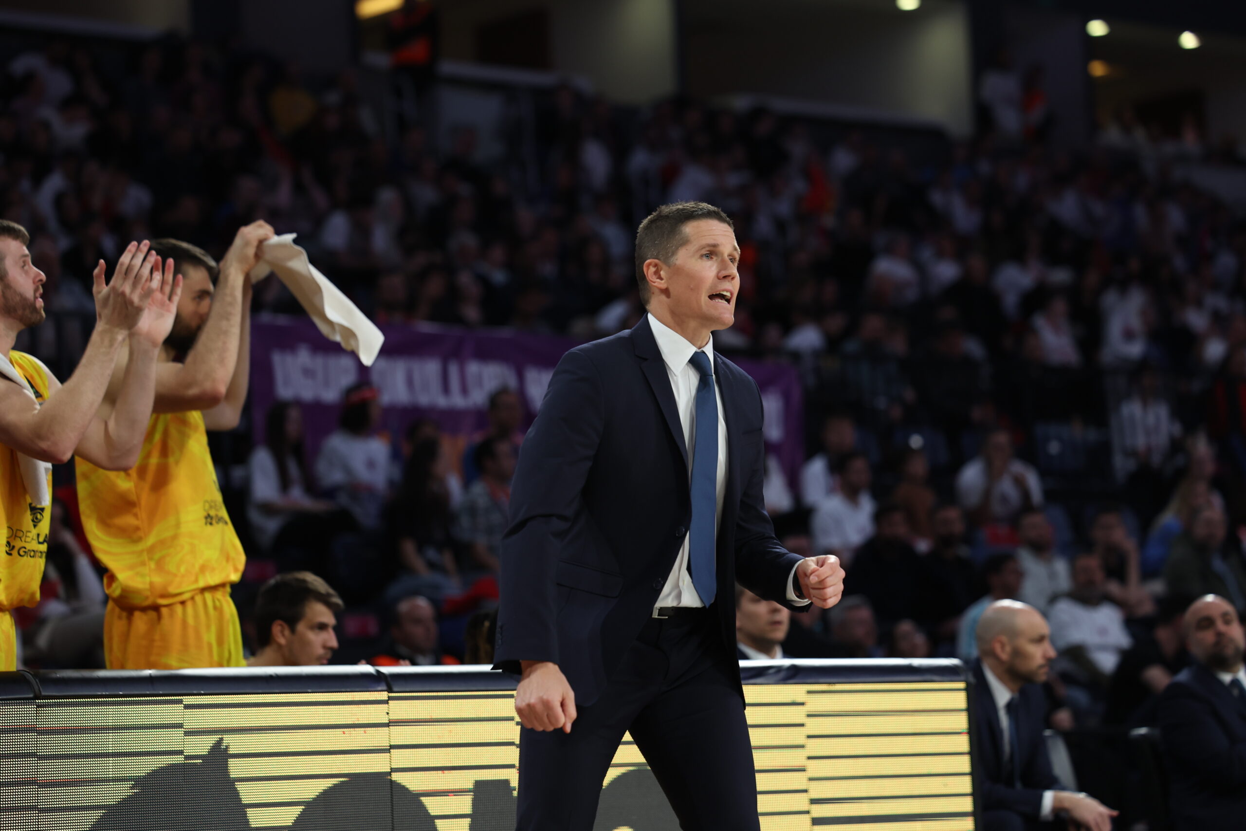 Jaka Lakovic dirigiendo al equipo con entusiasmo durante un partido de baloncesto.