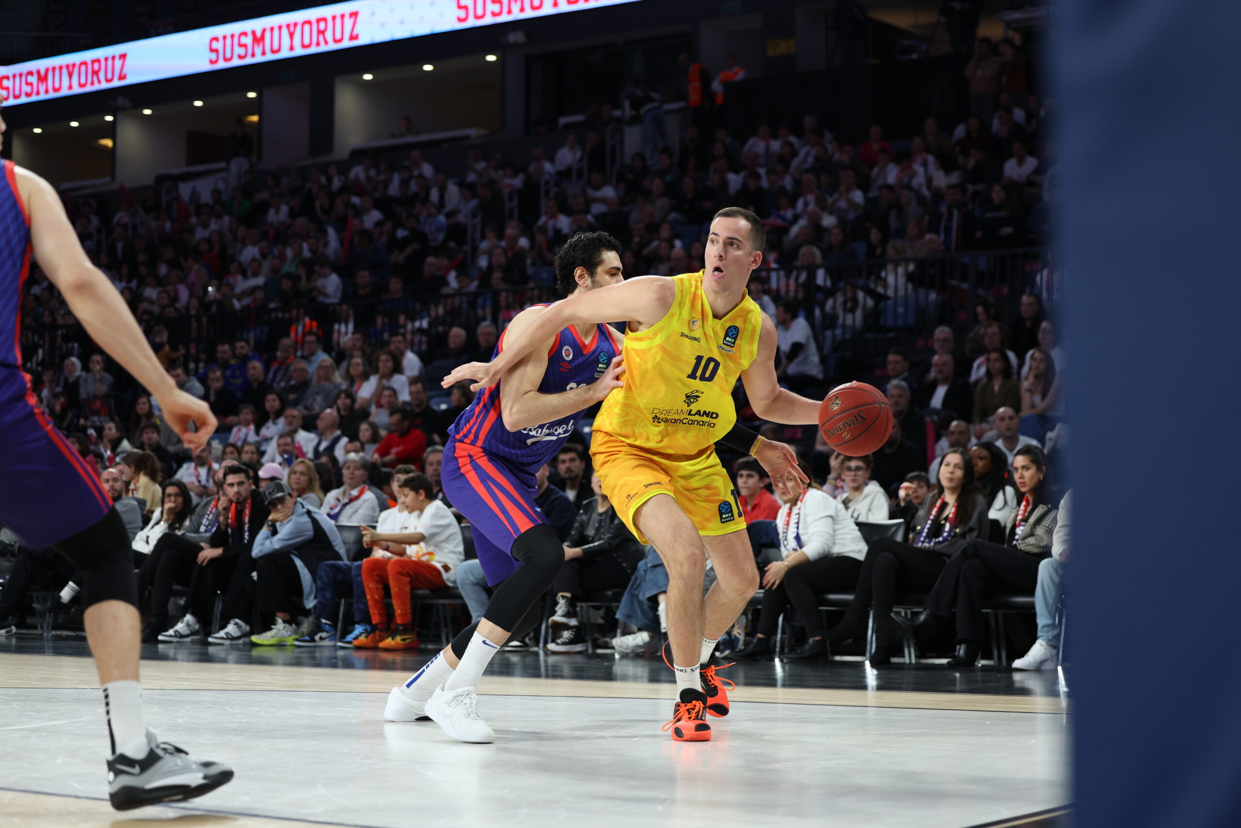 Jugador del Club Baloncesto Gran Canaria driblando el balón en un partido intenso.