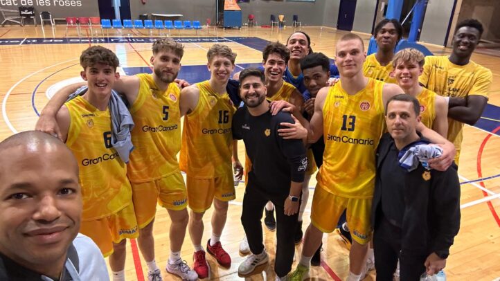 Jugadores del Gran Canaria posan sonrientes tras un partido en la cancha de baloncesto.
