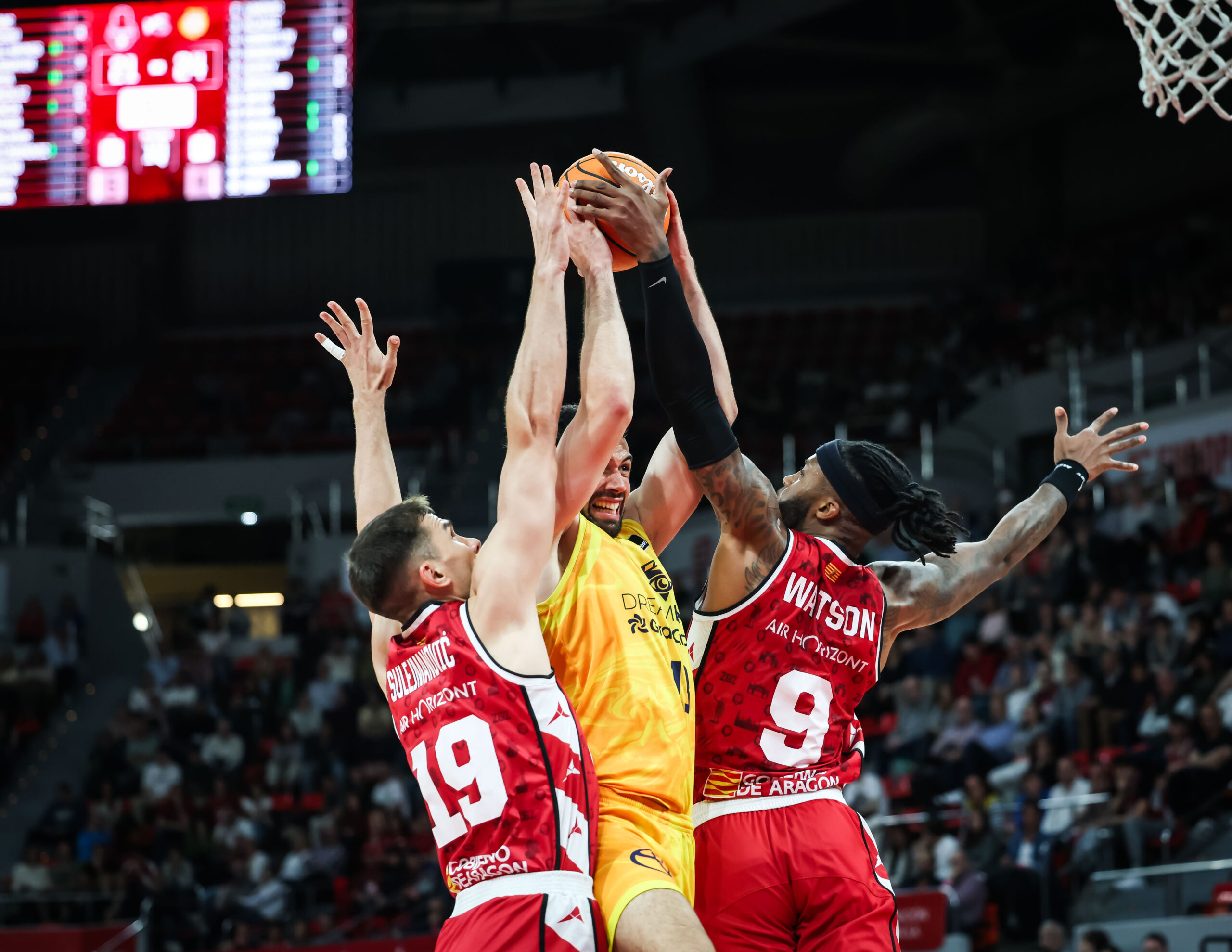 Jugador del Dreamland Gran Canaria intenta encestar entre dos defensores del Zaragoza.