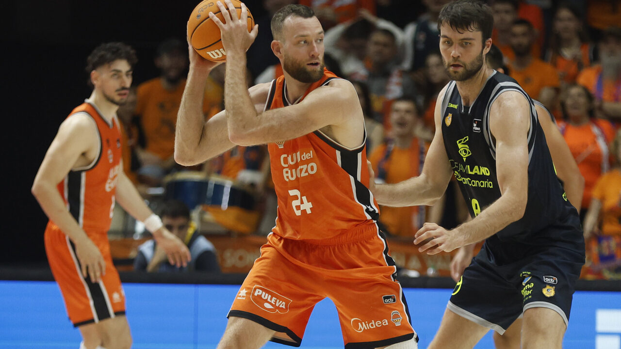 Jugadores de baloncesto en acción, con un jugador del Valencia Basket entre dos del Gran Canaria.