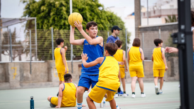 Jugadores de baloncesto en una cancha, durante un entrenamiento con entrenamiento juvenil.