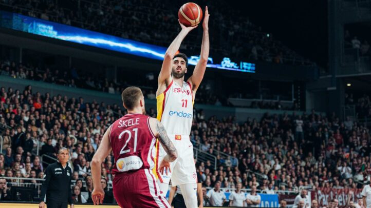 Baloncestista levantando el brazo para lanzar una pelota durante un partido.