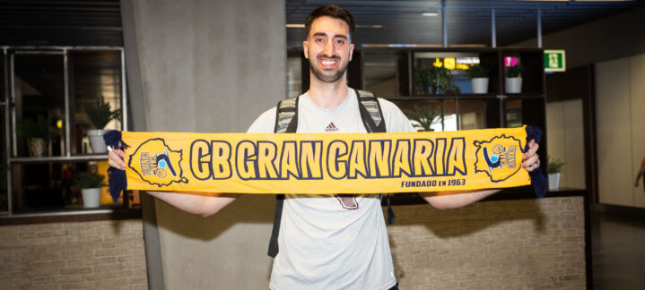 a su llegada: ""Lo que se me pida, lo haré""","Jugador sostiene una bufanda del CB Gran Canaria, sonriendo en un lugar de recepción.