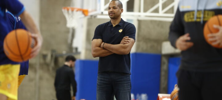 Eulis Báez observa el entrenamiento del equipo con balones de baloncesto.