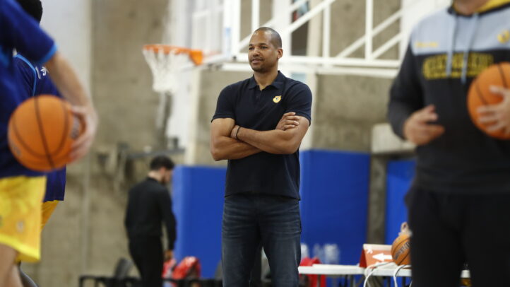 Eulis Báez observa el entrenamiento del equipo con balones de baloncesto.