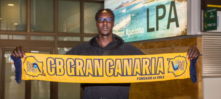 ya en Gran Canaria: ""Siempre intento dar energía a los compañeros y a los aficionados""",Jugador sosteniendo una bufanda del CB Gran Canaria en el aeropuerto.