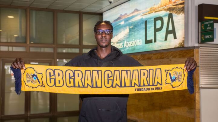 ya en Gran Canaria: ""Siempre intento dar energía a los compañeros y a los aficionados""",Jugador sosteniendo una bufanda del CB Gran Canaria en el aeropuerto.
