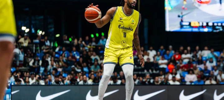 Braian Angola con balón, vistiendo uniforme amarillo de Colombia durante un partido.