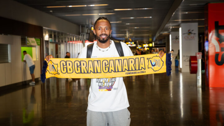 ya en la isla: ""Espero poder hacer algo importante con el equipo""",Jugador sosteniendo una bufanda del CB Gran Canaria en un aeropuerto.