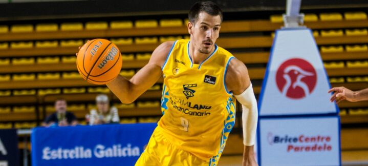 Jugador del Dreamland Gran Canaria driblando un balón de baloncesto en la cancha.