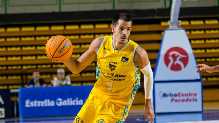 Jugador del Dreamland Gran Canaria driblando un balón de baloncesto en la cancha.