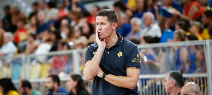 Entrenador Jaka Lakovic reflexionando durante un partido con afición al fondo.
