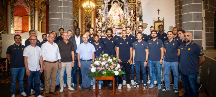 Jugadores y staff del Club Baloncesto Gran Canaria posan con una ofrenda floral.