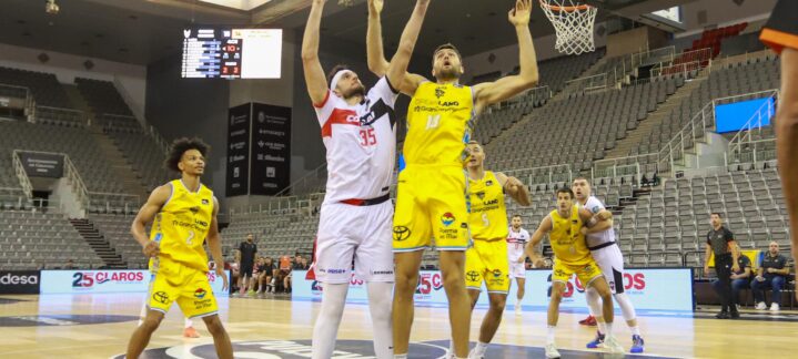 Jugadores compiten en un partido de baloncesto, con el equipo amarillo atacando.