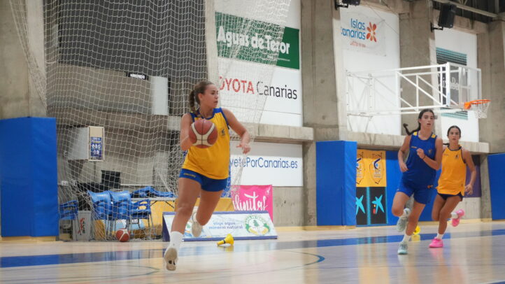 Jugadoras del junior femenino entrenando en la cancha, con balones de baloncesto.