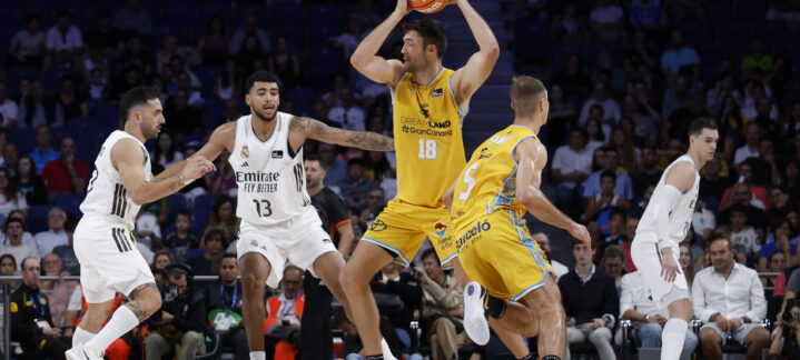 Jugadores de baloncesto durante un partido entre Gran Canaria y Real Madrid en acción.