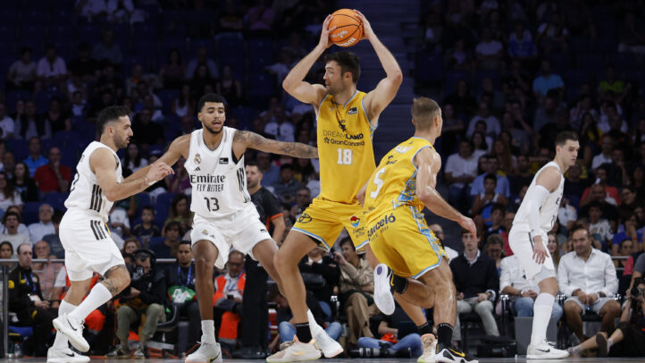 Jugadores de baloncesto durante un partido entre Gran Canaria y Real Madrid en acción.