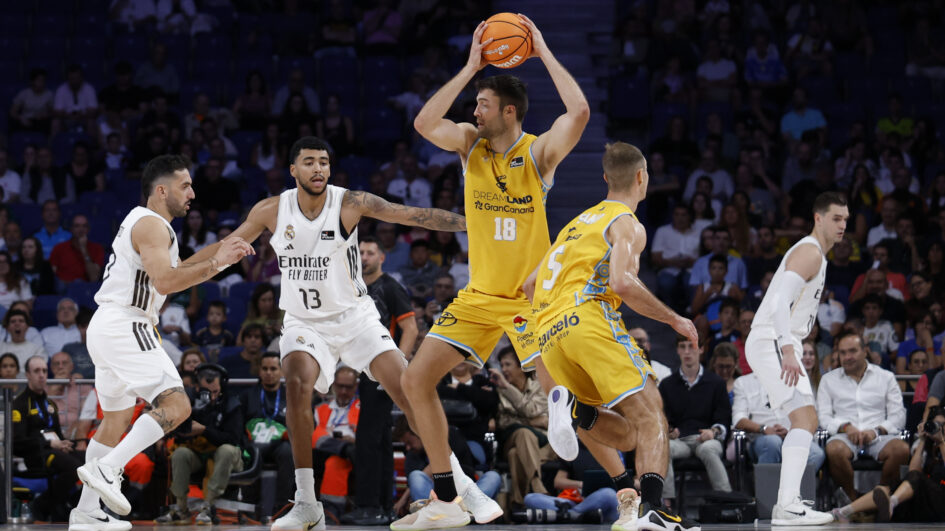 Jugadores de baloncesto durante un partido entre Gran Canaria y Real Madrid en acción.