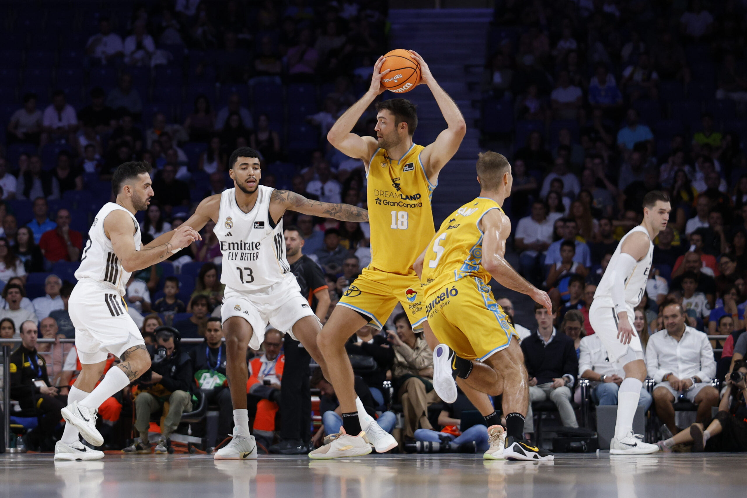 Jugadores de baloncesto durante un partido entre Gran Canaria y Real Madrid en acción.