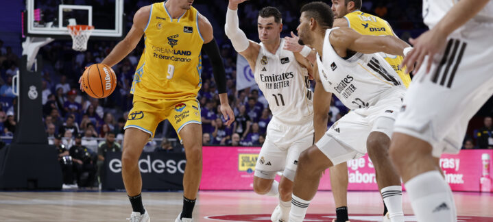 Jugador del Club Baloncesto Gran Canaria driblando ante defensores del equipo rival.