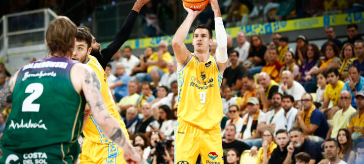 Jugador del Dreamland Gran Canaria lanzando a canasta en un partido lleno de espectadores.