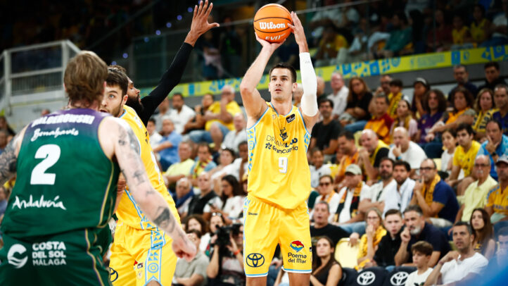 Jugador del Dreamland Gran Canaria lanzando a canasta en un partido lleno de espectadores.