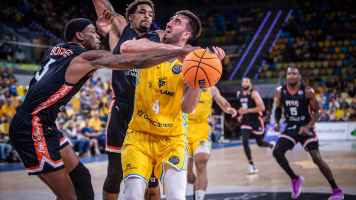 Jugador del Dreamland Gran Canaria intenta anotar mientras es defendido por rivales.