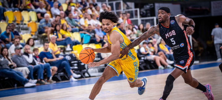 Jugador del Dreamland Gran Canaria conduce el balón mientras es defendido por un rival.