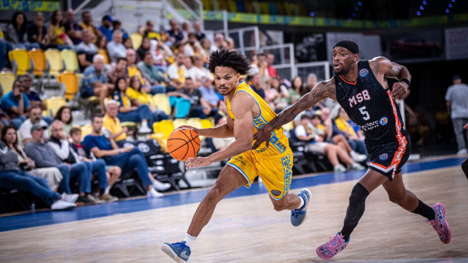 Jugador del Dreamland Gran Canaria conduce el balón mientras es defendido por un rival.