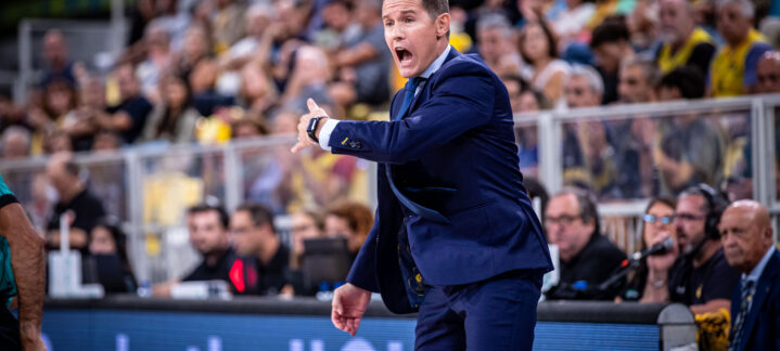 tenemos muchas oscilaciones""","Entrenador Jaka Lakovic dirigiendo instrucciones durante un partido, con público al fondo.